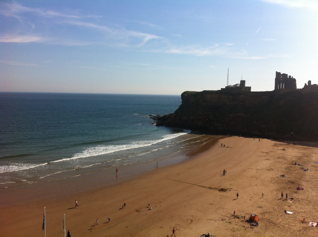 Tynemouth Beach - headland with ruins of castle overlooking sandy beach and blue sea