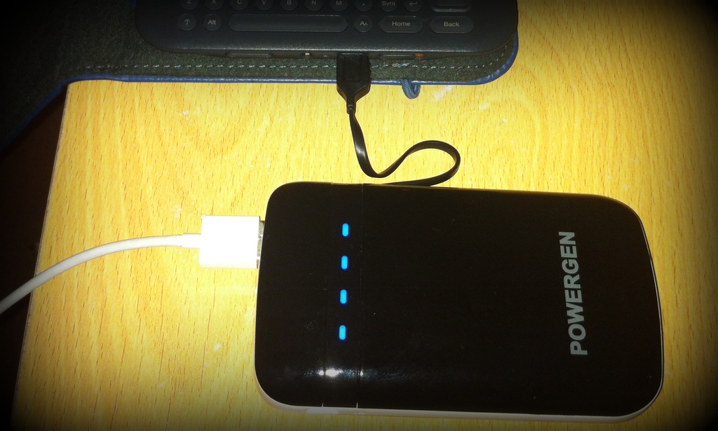 PowerGen Juice Pack with a Kindle plugged in to its integral micro-USB and an iPhone cable to one USB port